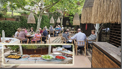 A group of people sitting at tables outside